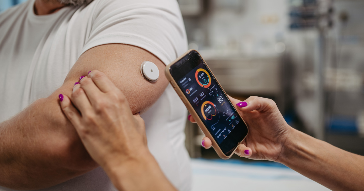 A smartphone being used to communicate with a medical device attached to a patient.