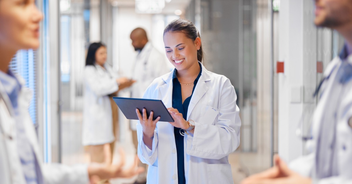 Doctor holding tablet and smiling