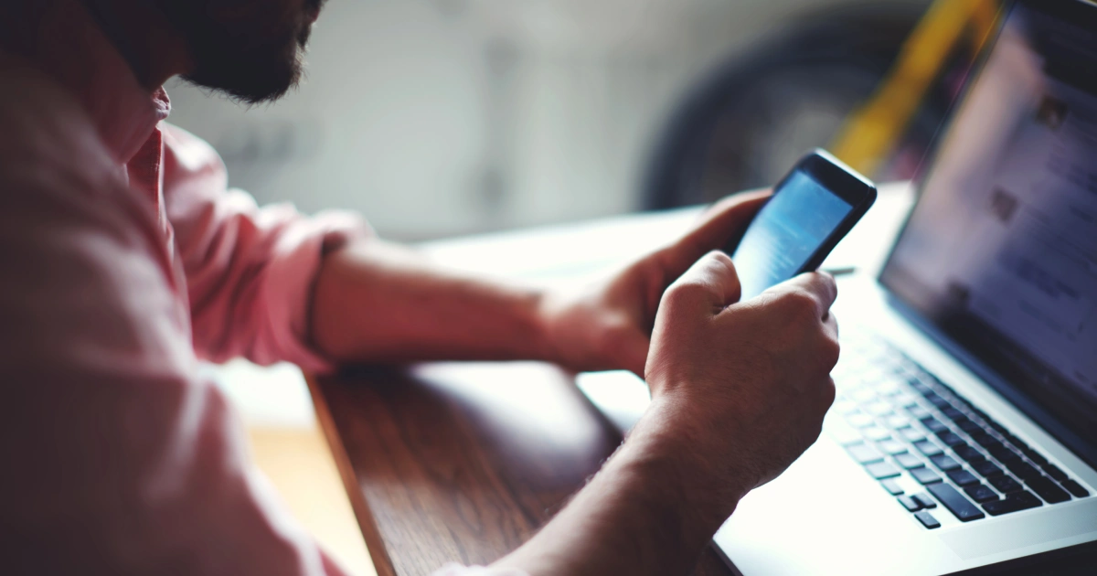 A man using an android phone while sitting at a desk
