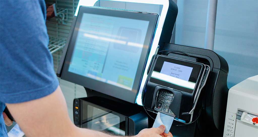 Man Using Self Kiosk At Retail Store