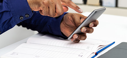 man using smartphone for fleet scheduling